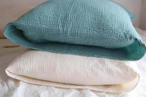 Două fețe de pernă din muselină dublă, verde și albă, cu textură aerată și moale.