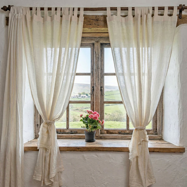 Draperie din in semi-transparent cu bride de prindere, căzând elegant pe podea într-o lumină caldă.